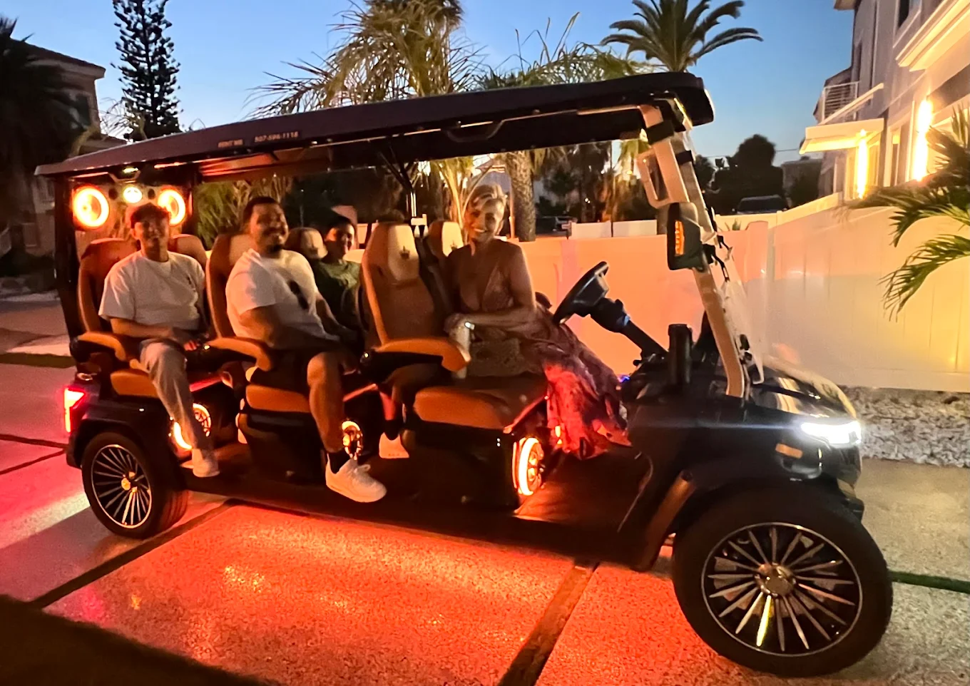 Sandy Golf Cart Rentals black 6-passenger street-legal golf cart with cognac leather seats and custom alloy wheels parked in Clearwater Beach